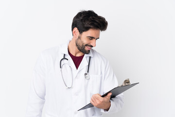 Young handsome man with beard over isolated white background wearing a doctor gown and holding a folder