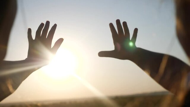 hands in the sun. mom and daughter hands reach out to the sun silhouette sunlight. happy family kid dream concept. mom and daughter dream of god sunset religion concept
