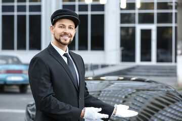 Portrait of handsome chauffeur near luxury car