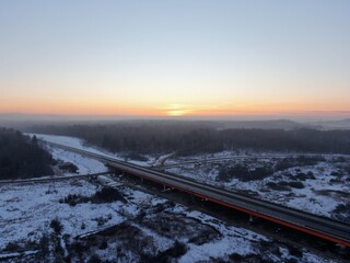 Aerial view of the Central Ring Road (CKAD) at sunrise. Beautiful panoramic landscape of a straight road overlooking the horizon. Travel by car in winter