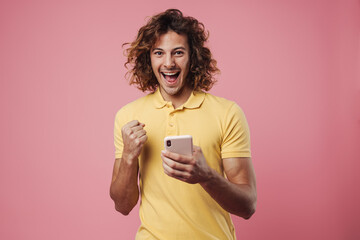 Portrait of an excited young man using mobile phone