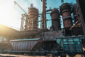 Blast furnace of metallurgical plant or chemical factory with industrial railroad and freight wagons.