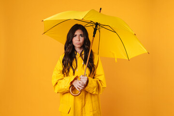 Portrait of an upset girl dressed in raincoat standing