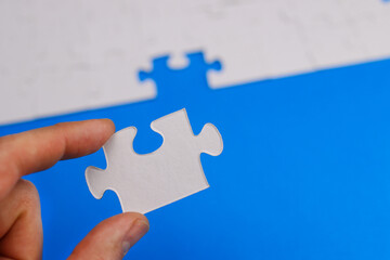 missing piece of the puzzle is inserted by the hand into its place