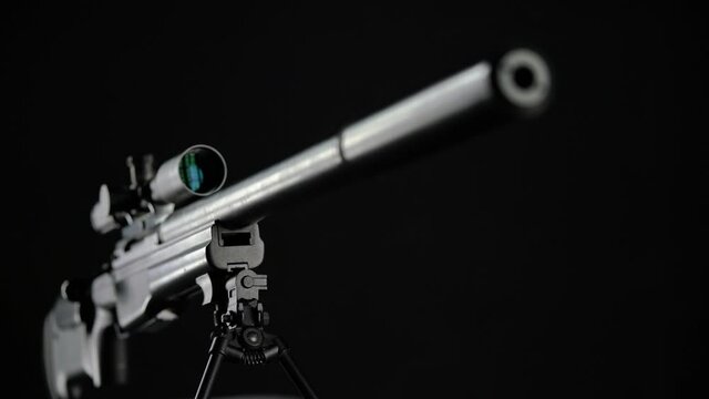 focus and pan from the top of the silencer to the butt of Sniper rifle Sako TRG 41 on black background