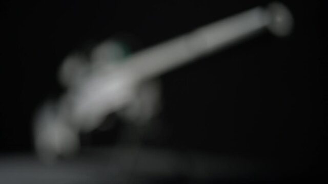 focus and movement from the butt of the silencer to the top of Sniper rifle Sako TRG 41 on black background