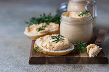 Homemade pate, spread or mousse in glass jar with sliced bread and herbs, light concrete background. - obrazy, fototapety, plakaty