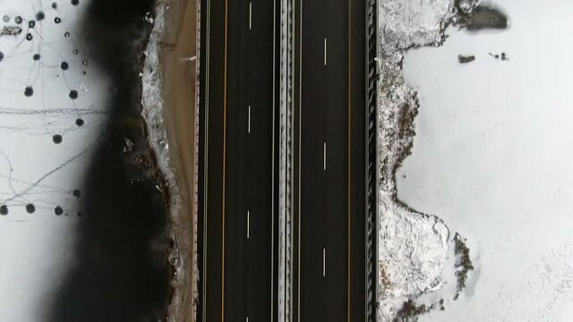 Aerial view black canvas of a new high-speed highway with applied road markings against the background of white snow