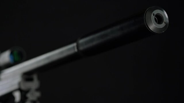 focus and movement from the butt of the silencer to the top of Sniper rifle Sako TRG 41 on black background