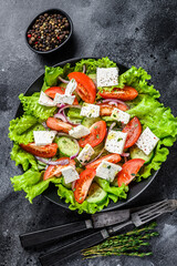 Bowl of ready-to-eat Greek salad. Black background. Top view