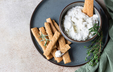 Blue cheese dressing or dip sauce with rosemary and gingerbread cookies sticks on concrete background. - obrazy, fototapety, plakaty