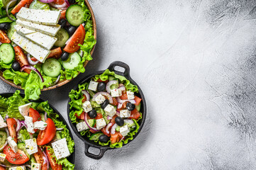 Selection of traditional Greek salad in a bowls. White background. Top view. Copy space