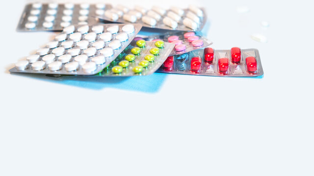 packaging of multicolored tablets on a white background, blurred image, medicines