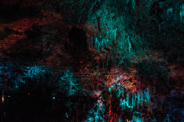 Stalagmites lit by colored lights, cave, Lozère, Occitanie, France