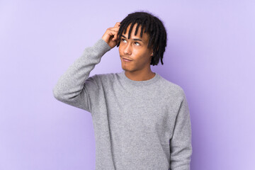 Fototapeta na wymiar Young african american man isolated on purple background having doubts and with confuse face expression
