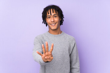 Young african american man isolated on purple background happy and counting four with fingers