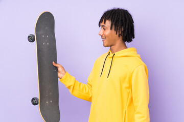 Handsome young skater man over isolated wall with happy expression