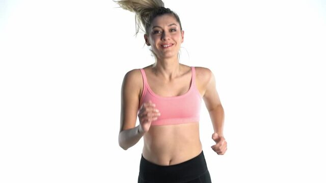 Slow motion of sporty happy woman jumping on white background. front view