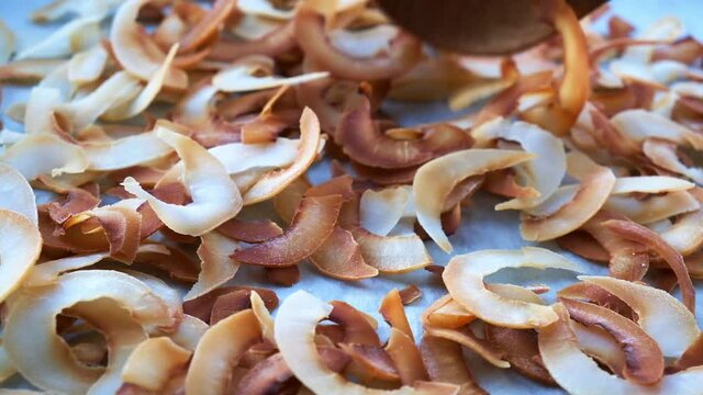 Golden baked coconut chips on a baking sheet. Healthy food concept.