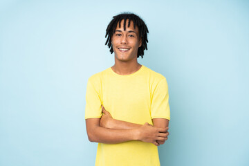 Young african american man isolated on blue background with arms crossed and looking forward