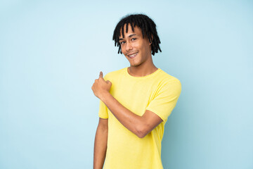 Young african american man isolated on blue background pointing back