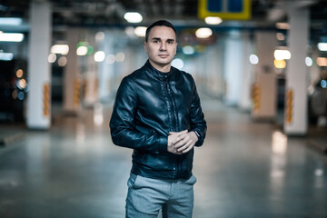 Fototapeta premium Portrait of a handsome young man. Shooting in a car park
