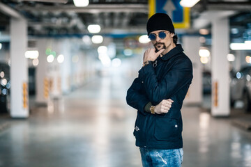 Portrait of a handsome young man. Shooting in a car park
