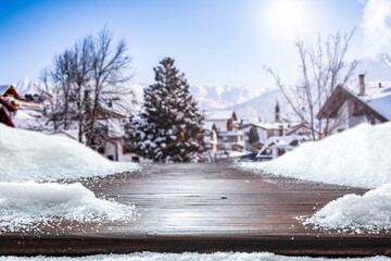 Fresh snow on a wooden table surrounded by an alpine view of the mountains