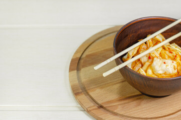Kimchi cabbage in bowl with chopsticks, Korean food.