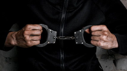 Close-up of hands in handcuffs, female prisoner, arrested woman in handcuffs. The concept of crime
