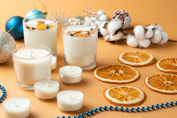 milky candles, citrus fruits, christmas decor, pastel background, orange.