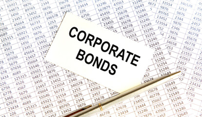 Obraz premium On the business card the text of CORPORATE BONDS, the background are reports, next to the pen.
