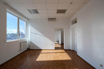 Modern interior of empty office rooms. White walls. Huge window. Sunny day.