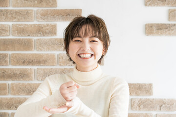 両手でひらめきのポーズをする若い女性