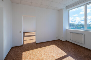 Modern interior of empty office room. White walls. Huge window. View of cargo port at sunny day.