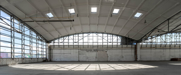 Huge empty industrial warehouse. White interior. Unique architecture. Hemispherical reinforced concrete load bearing roof. Modern building.