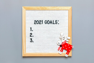Text - 2021 goals Motivational quotes on message felt board, deer on gray background Planning, self motivation, achievement, success, wish list, checklist, Christmas concept Top view Flat lay