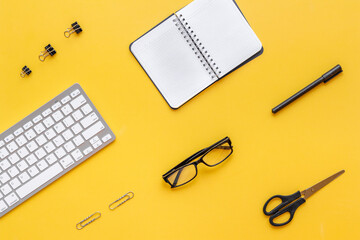Yellow flat lay top view office table desk with keyboard and office supplies