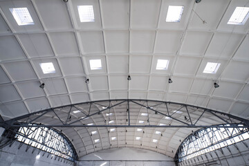 Hemispherical reinforced concrete load bearing roof with windows in huge industrial warehouse. White interior. Unique soviet architecture.