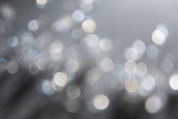 Abstract bokeh effect background in grey colours with rainbow rays.