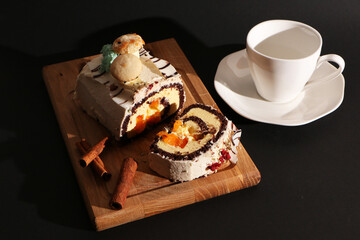 Food - a beautiful birthday cake with a cup of coffee on a wooden board.The background is black.