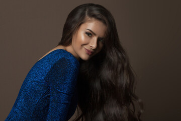 Fototapeta premium Young model woman brunette with healthy hairstyle on brown background, fashion beauty portrait