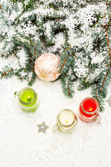 Colorful candles in glass jars with New Year's decor