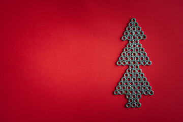 Christmas tree made of silver metal nuts. Winter holidays concept. Creative modern idea. Flat lay, top view, copy space