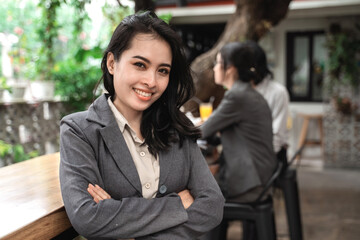 Portrait cheerful of young asian business woman meeting in a cafe. With friends in the background