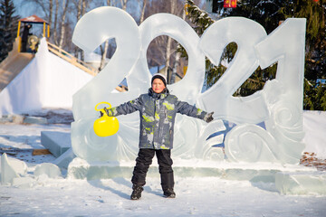 happy boy stands on the background of ice figures