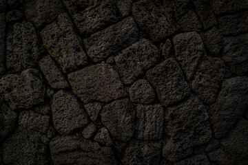 coarse-textured black background with many holes in basalt stone. - obrazy, fototapety, plakaty