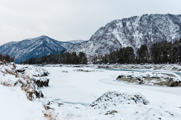 big rocks in river at winter. The trees and stones are covered with snow
