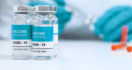 Corona virus, Sars-Cov-2 vaccine concept. Doctor hands in blue medical gloves with transparent liquid coronavirus vaccine bottle and syringe for injection in the laboratory.  