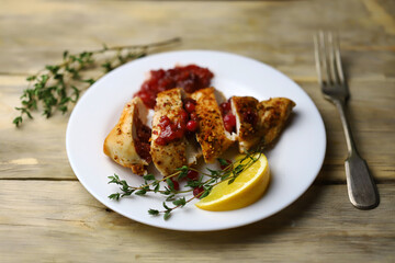 Juicy turkey fillet in slices with cranberry sauce on a plate. Festive food.
